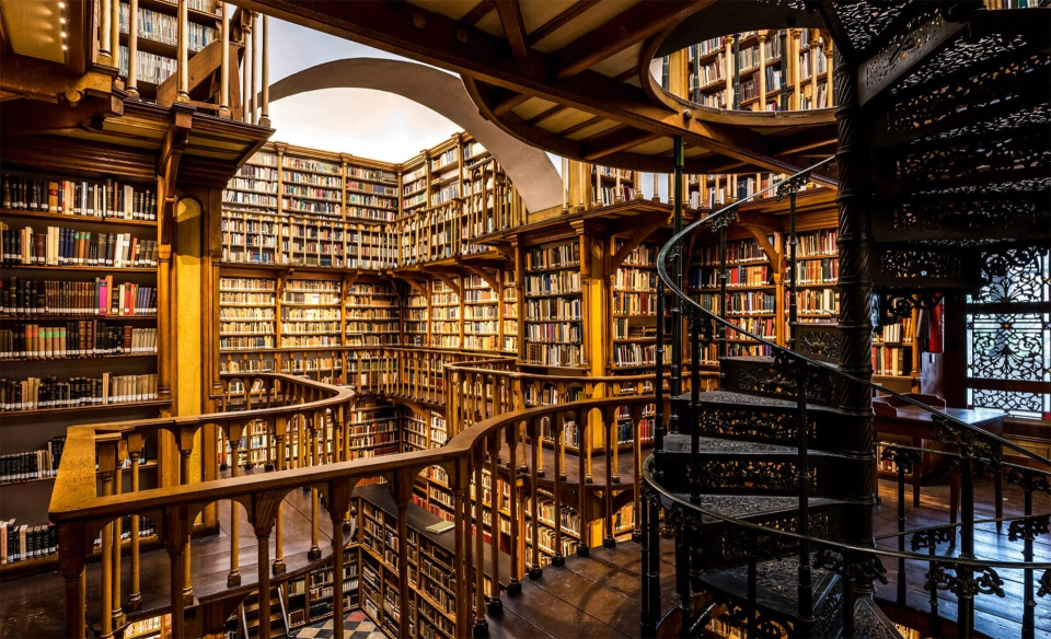 A desk with a stack of classic books and an open journal